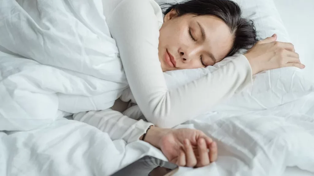 A woman sleeping peacefully in a bed.