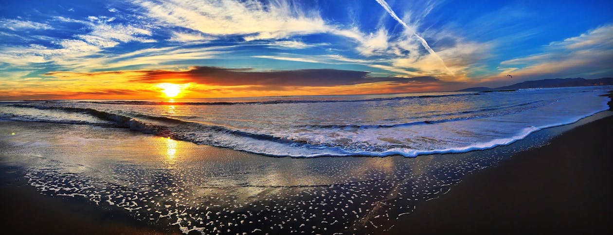 Wide landscape of beach at sunset.